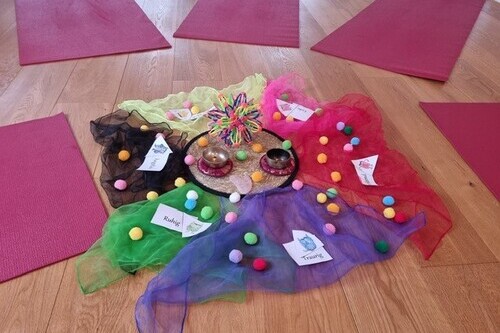 Vorbereitet für Kinderyoga mit bunten Matten und Tüchern, Klangschalen und Themnkärtchen stehen bereit