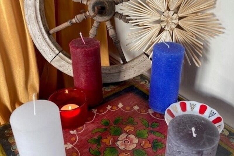 Weihnachtsdeko mit Kerzen, Strohstern und einem Spinnrad